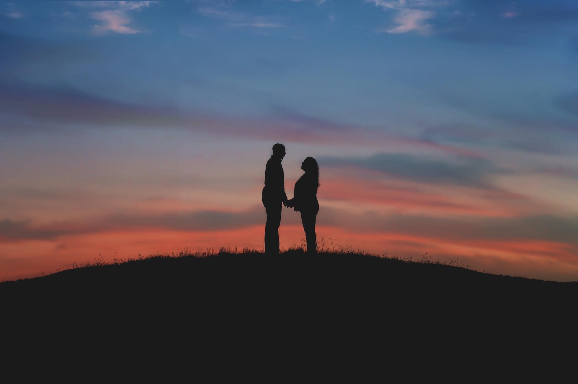 couple-silhouette-hill-at-sunset