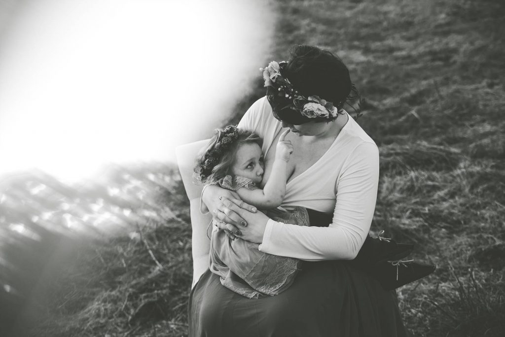 Black and white photo of mom breastfeeding toddler girl